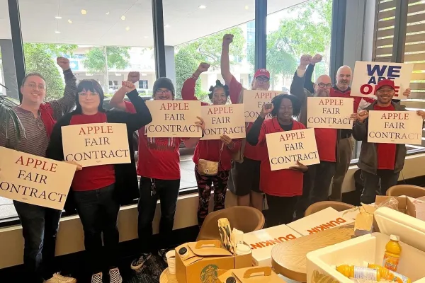 CWA Apple workers holding Fair Contract signs