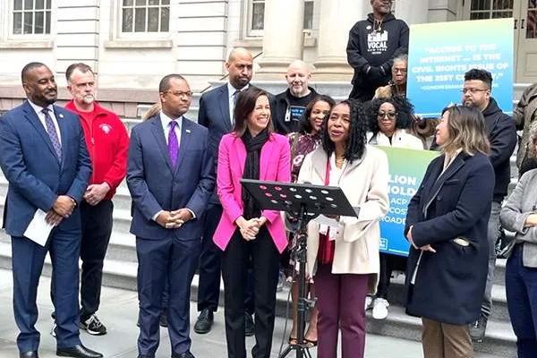 Congresswoman Yvette Clarke (D-N.Y.) stands with FCC Chairwoman Jessica Rosenworcel (in pink jacket) and CWA members