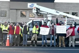 CWA workers wearing red stand in front of TDS building
