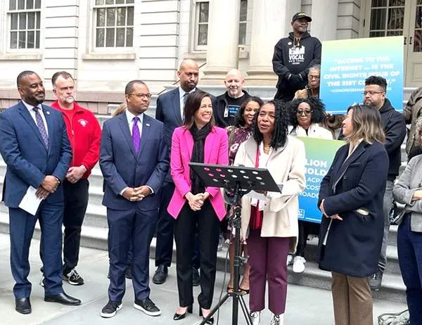 Congresswoman Yvette Clarke (D-N.Y.) stands with FCC Chairwoman Jessica Rosenworcel (in pink jacket) and CWA members