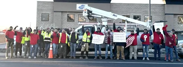 CWA workers wearing red stand in front of TDS building